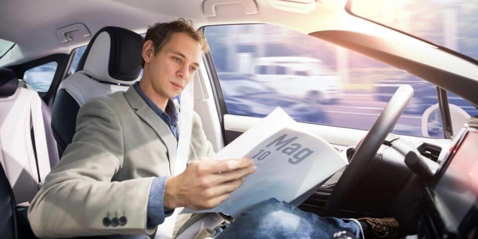 Western man reading a book in the driver's seat
