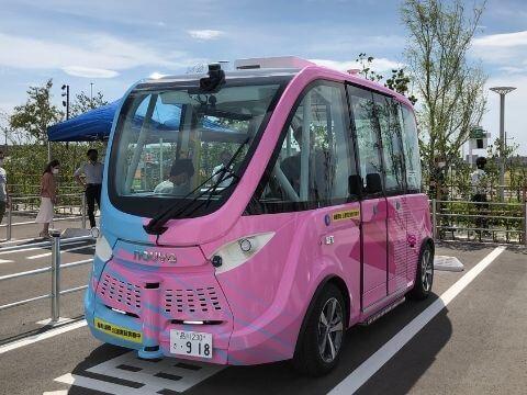Parked pink autonomous driving shuttle bus