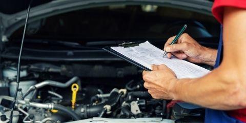 Worker inspecting the hood of a car